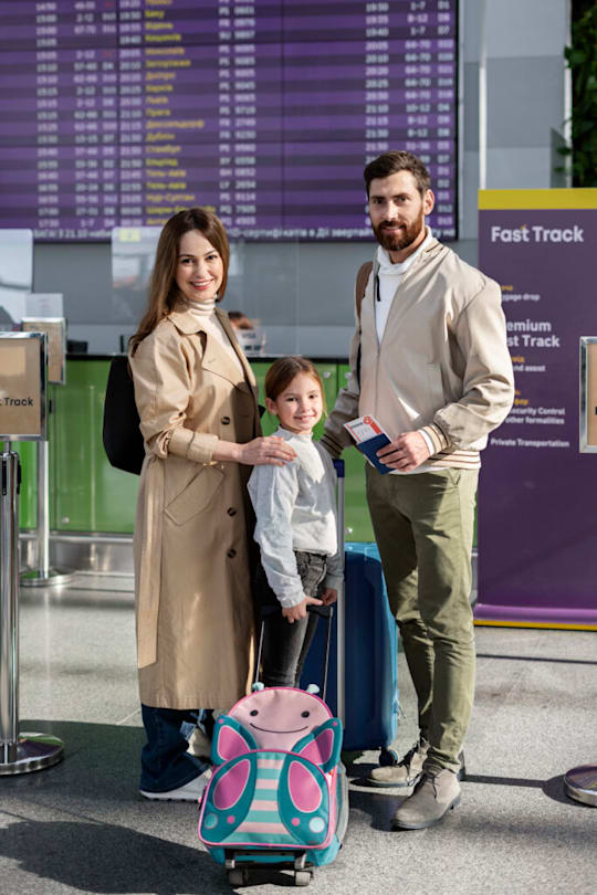 Family group with luggage ready for their minibus taxi to East Midlands Airport
